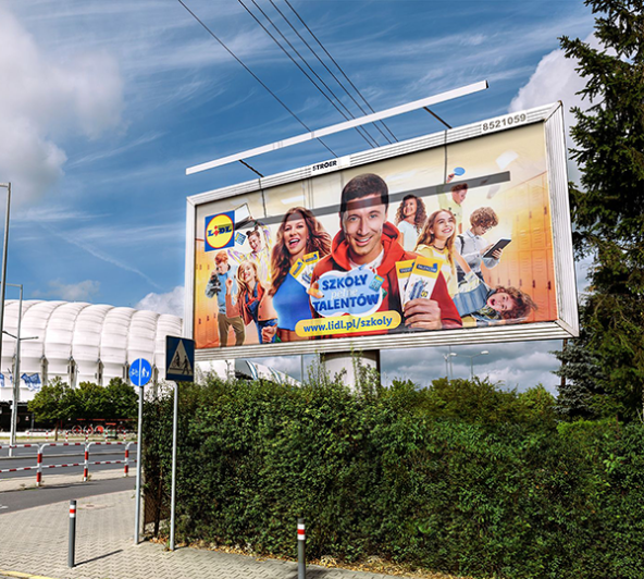 A billboard in front of the PGE Narodowy stadium in Warsaw promotes a Lidl TCC community campaign, featuring several smiling young people including Robert Lewandowski and Anna Lewandowska