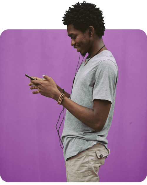 A man enjoying music through headphones while focused on his phone, immersed in his digital experience.